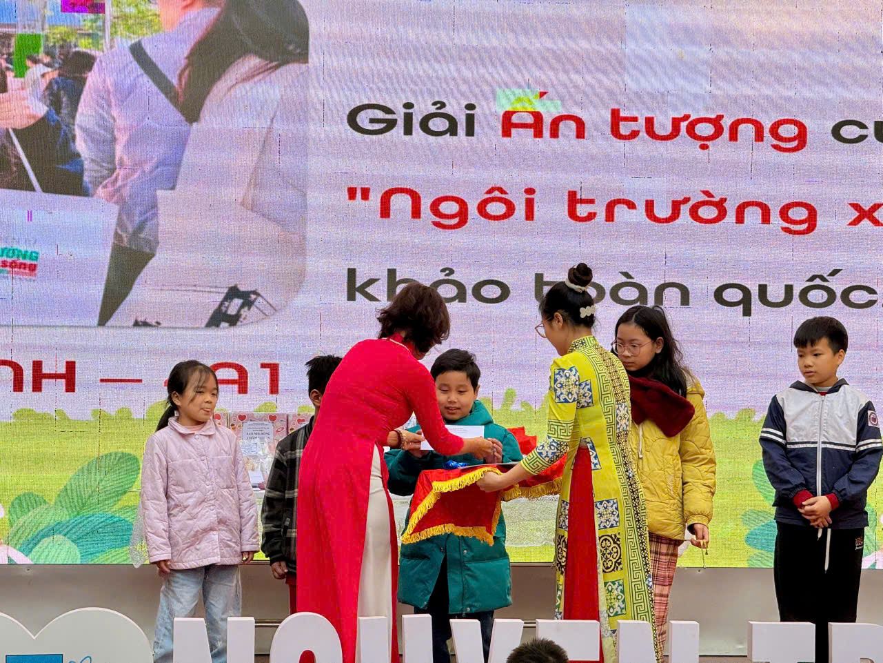 A group of people standing around a sign

Description automatically generated