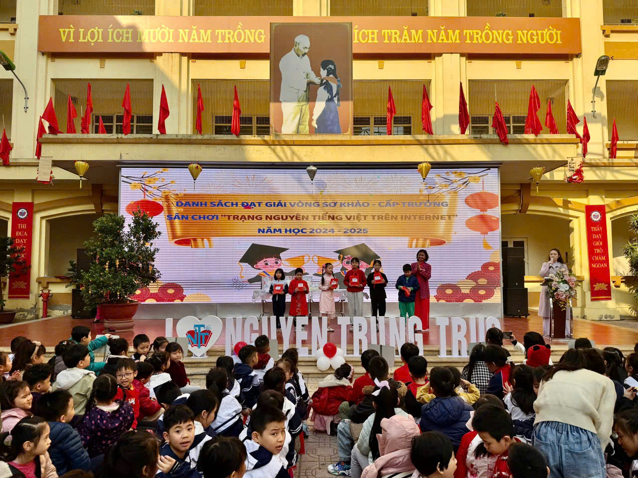 A group of children sitting on a stage

Description automatically generated