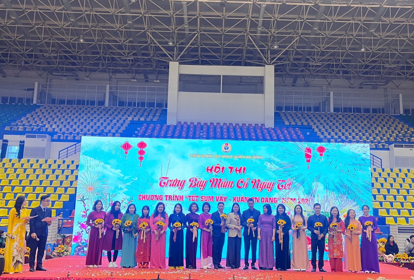 A group of people standing in front of a stage

Description automatically generated