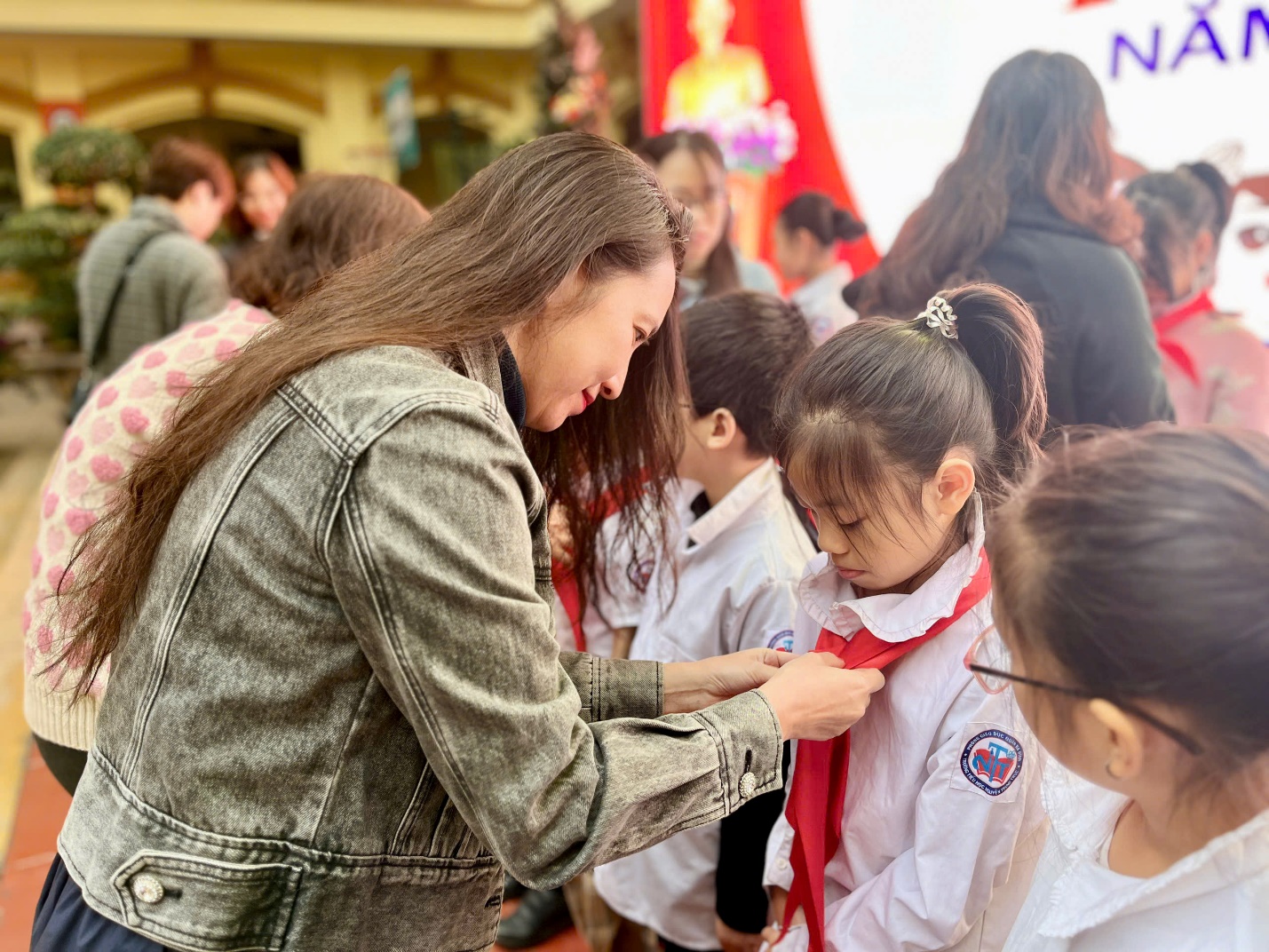 A person helping a child with a tie

Description automatically generated