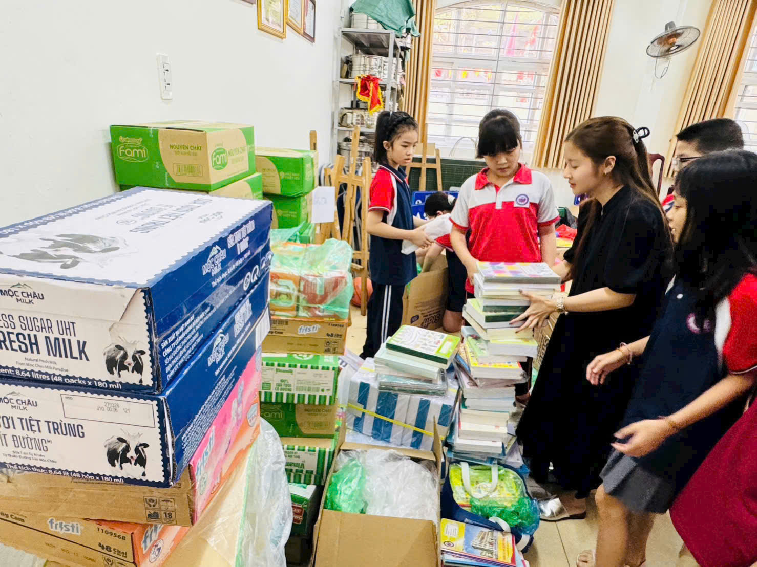 A group of people in a room with boxes and books
AI-generated content may be incorrect.