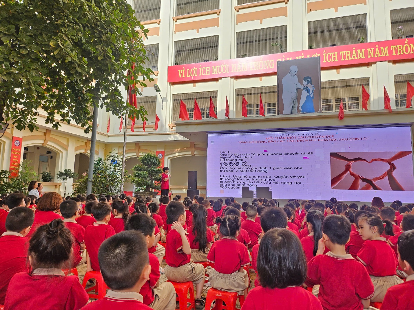 A group of children in red shirts sitting in front of a large screen

AI-generated content may be incorrect.
