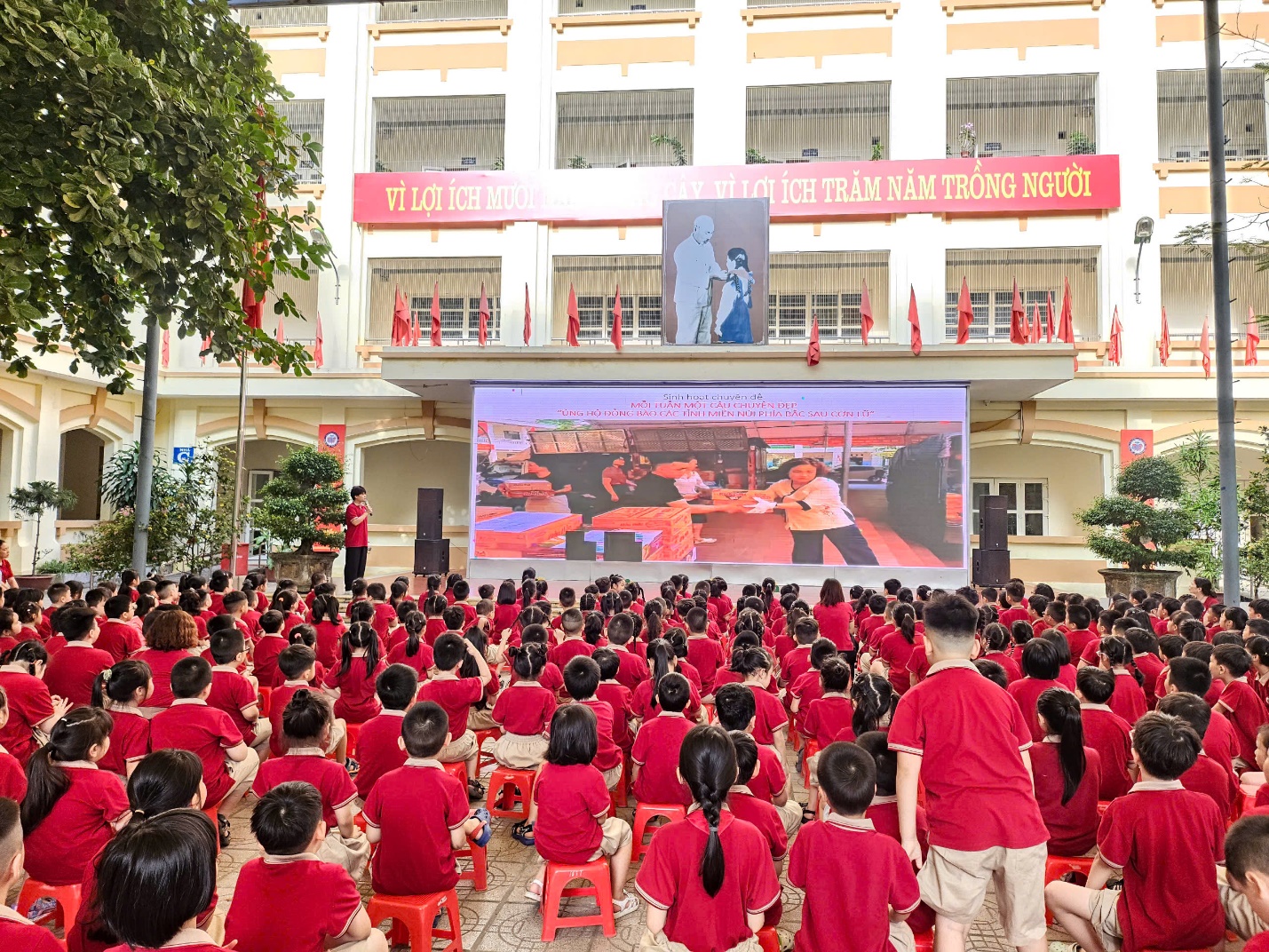 A group of children in red shirts sitting in front of a large screen

AI-generated content may be incorrect.