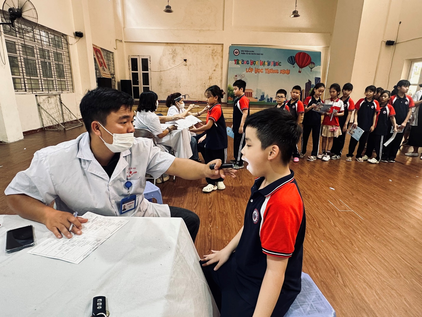 A person shaking hands with a child in a room with other people

AI-generated content may be incorrect.