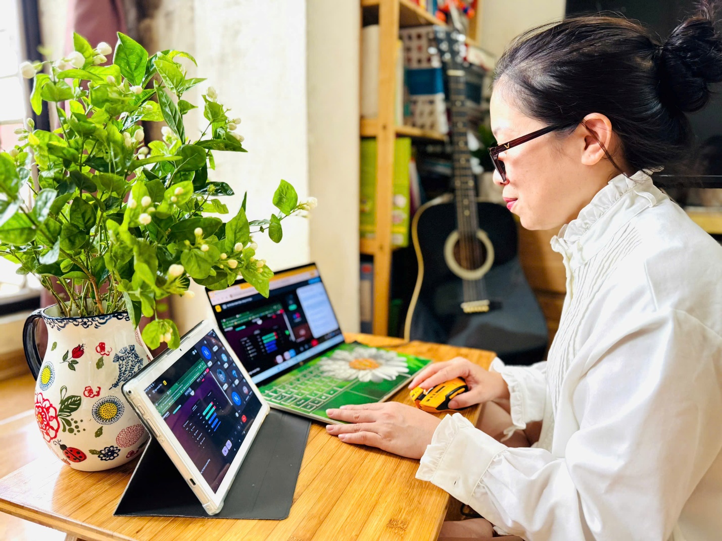 A person sitting at a table with a computer and a plant
AI-generated content may be incorrect.