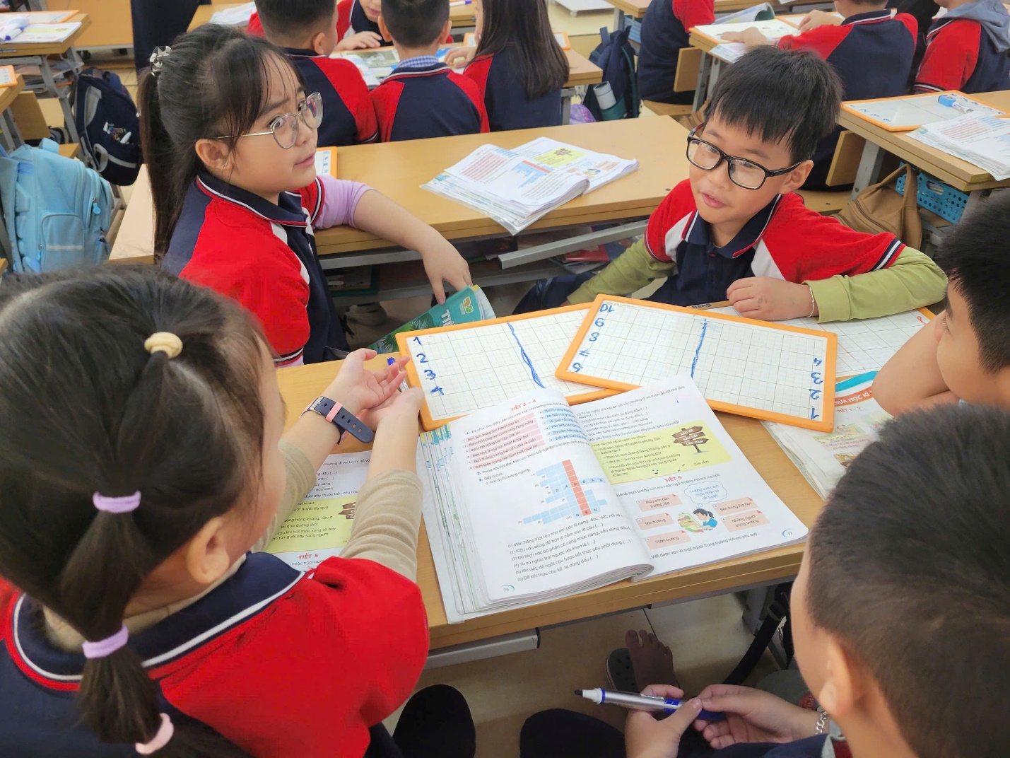 A group of children sitting at desks in a classroom

AI-generated content may be incorrect.