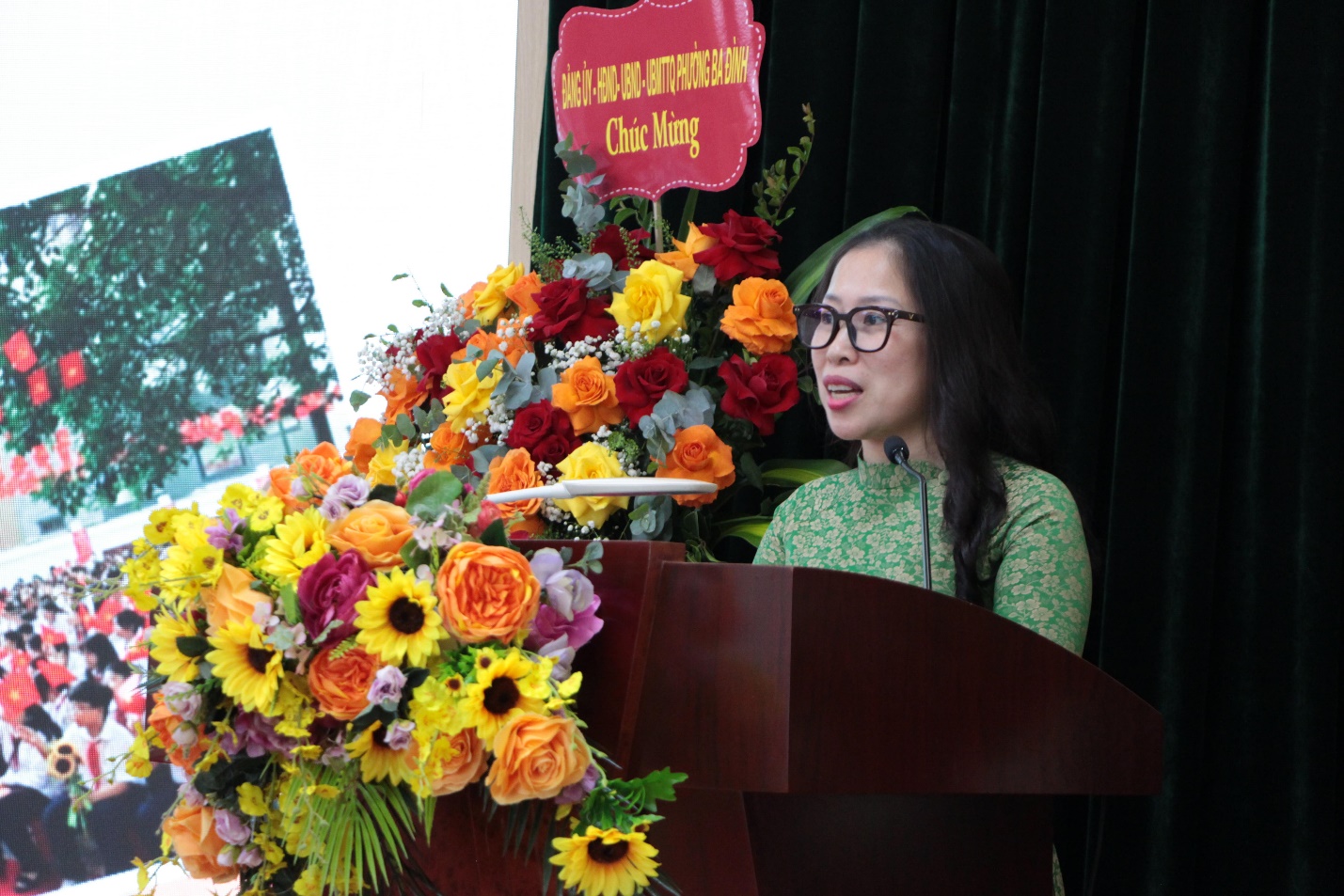 A person standing at a podium with flowers

AI-generated content may be incorrect.