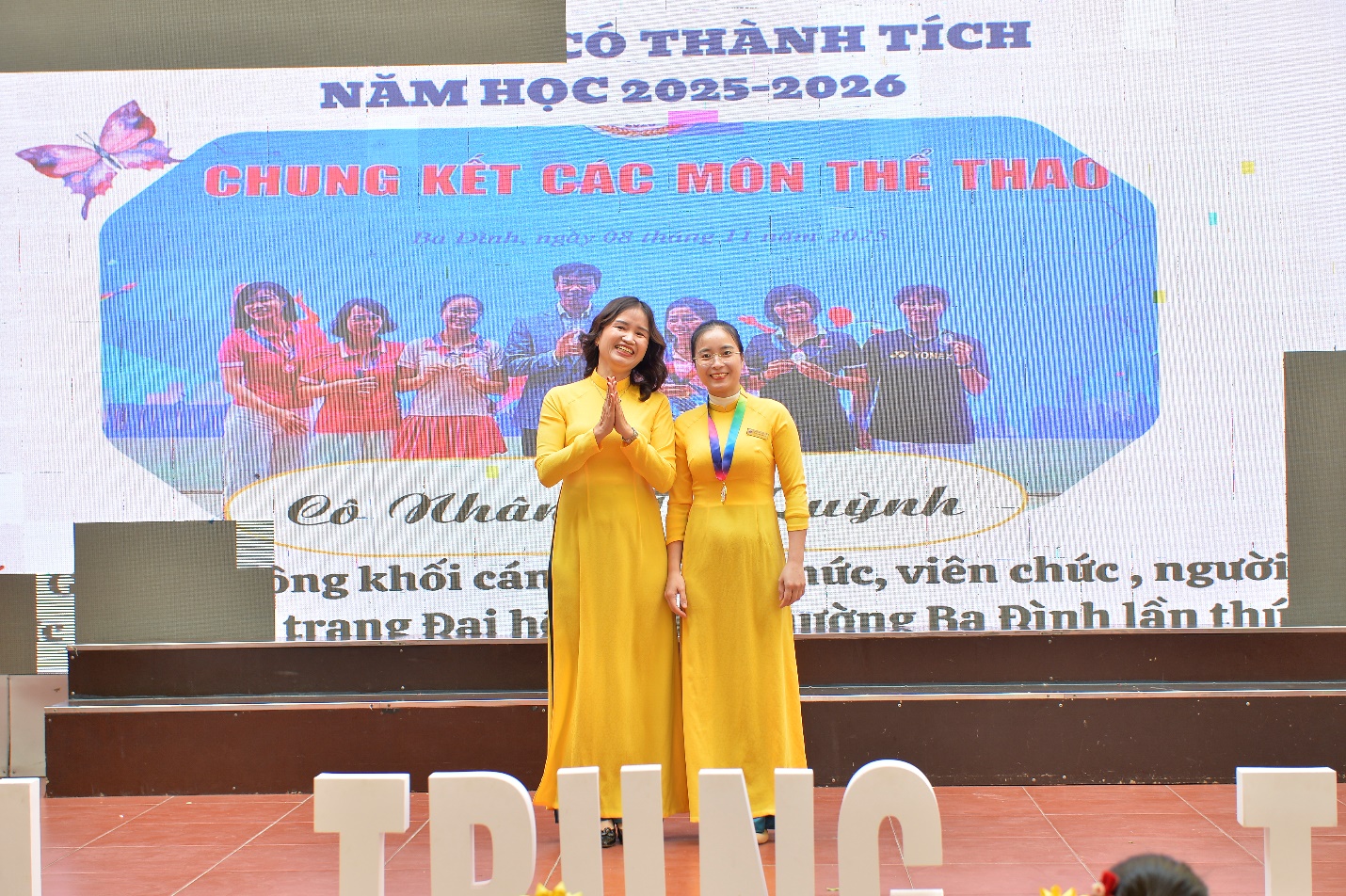 Two women in yellow dresses standing in front of a large screen

AI-generated content may be incorrect.
