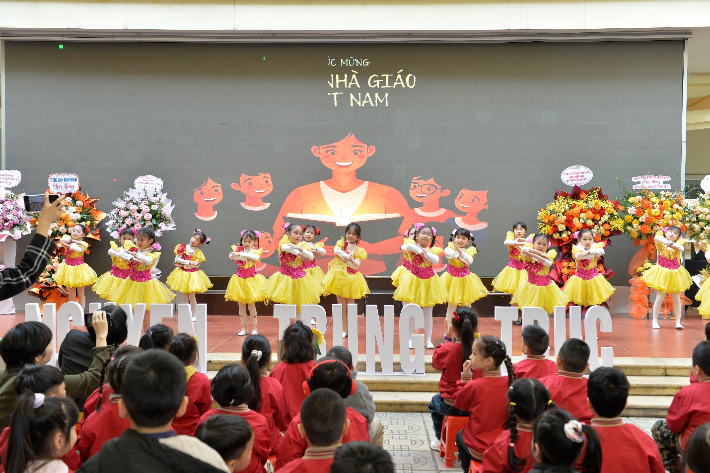 A group of children performing in front of a wall

AI-generated content may be incorrect.