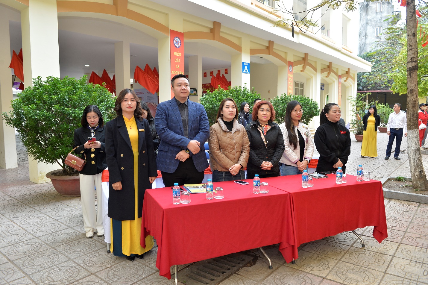 A group of people standing next to a table

AI-generated content may be incorrect.