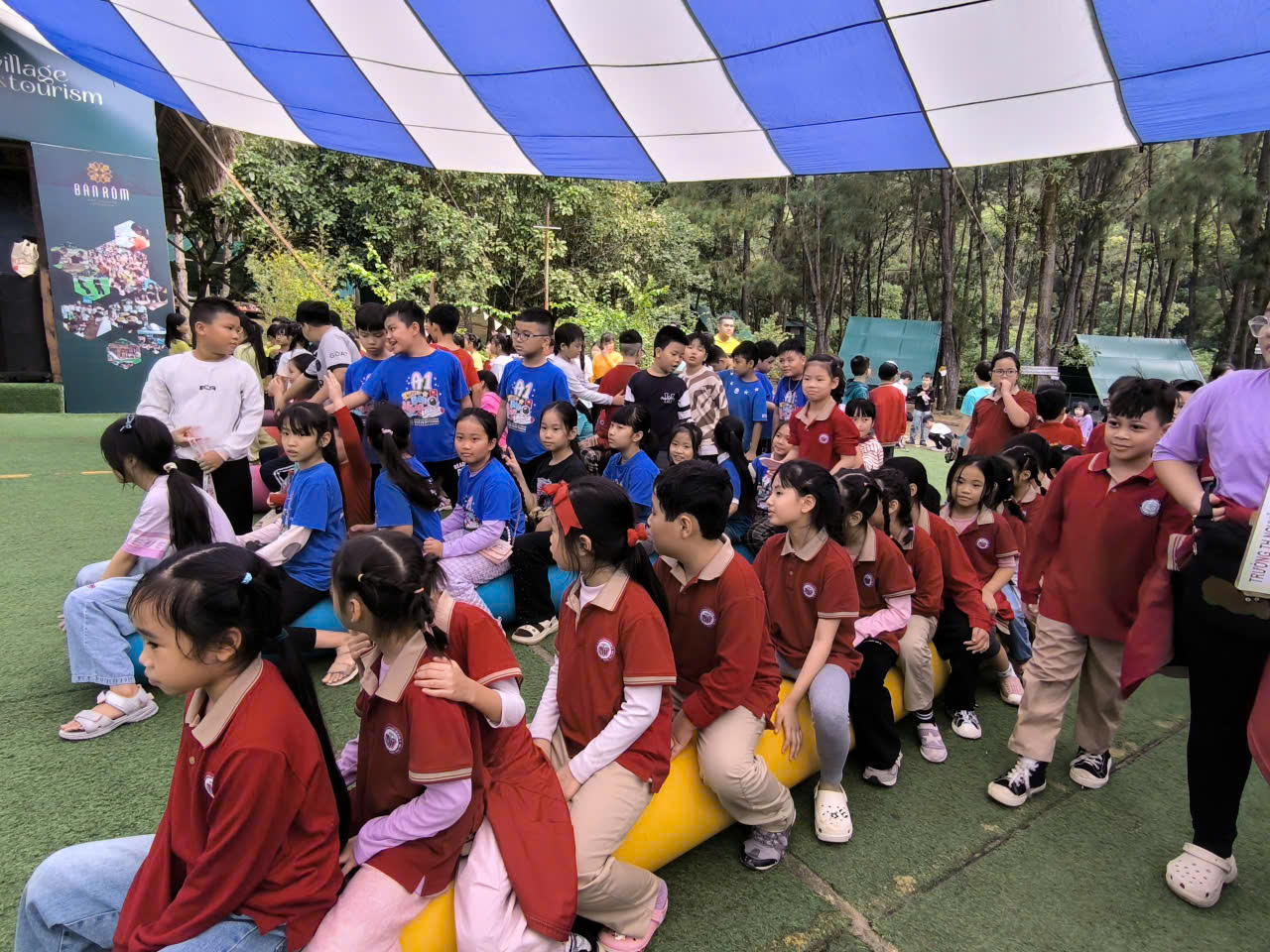 A group of children sitting on an inflatable raft under a tent

AI-generated content may be incorrect.