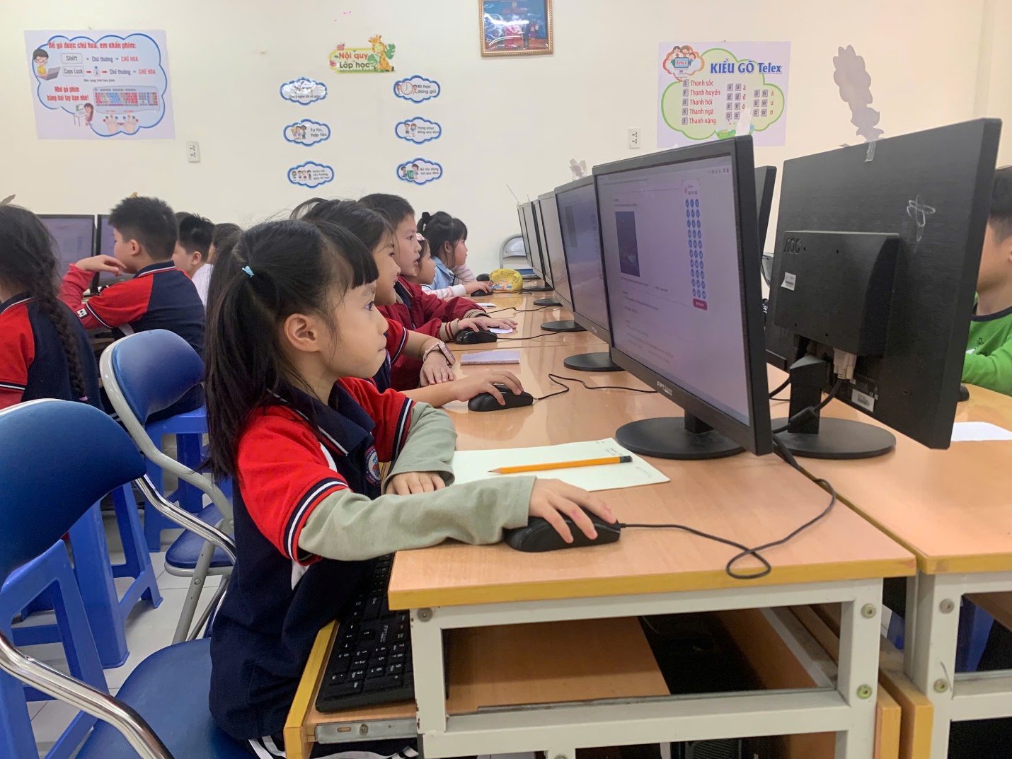 A group of children sitting at a desk with computers

AI-generated content may be incorrect.