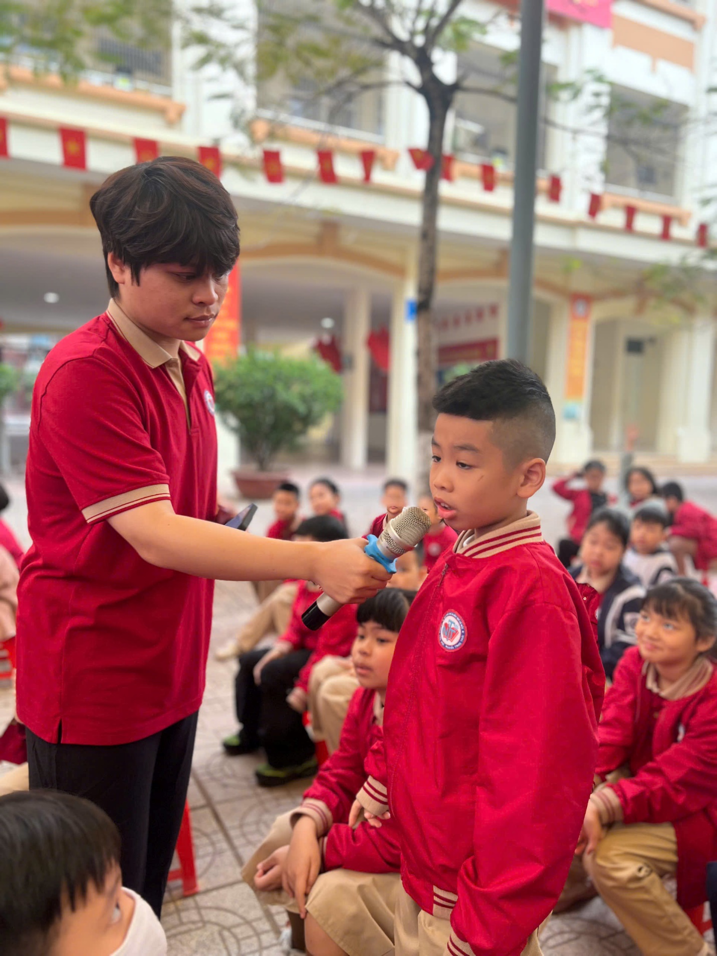 A person holding a microphone to a child

AI-generated content may be incorrect.