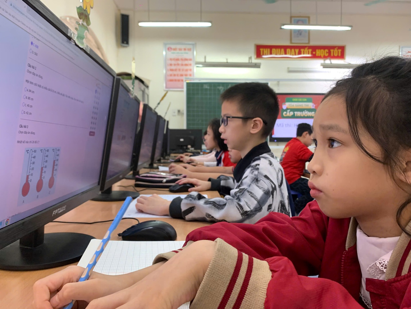 A group of children sitting at a desk with computers

AI-generated content may be incorrect.