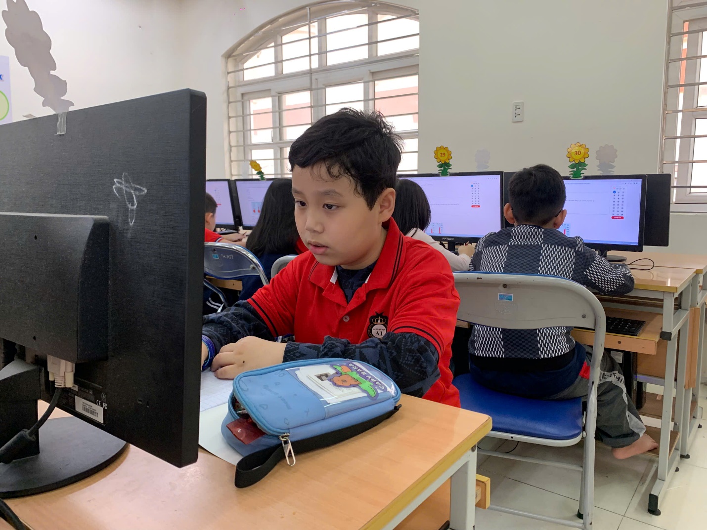 A child sitting at a desk in front of a computer

AI-generated content may be incorrect.