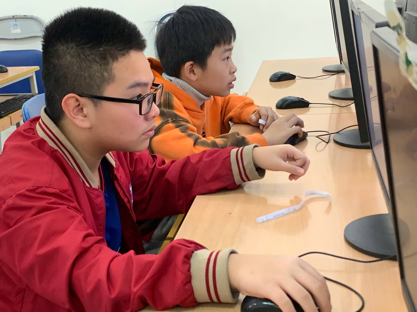 A group of boys sitting at a table using computers

AI-generated content may be incorrect.