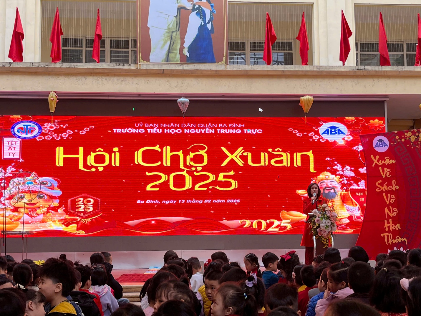 A group of people in front of a large screen

Description automatically generated