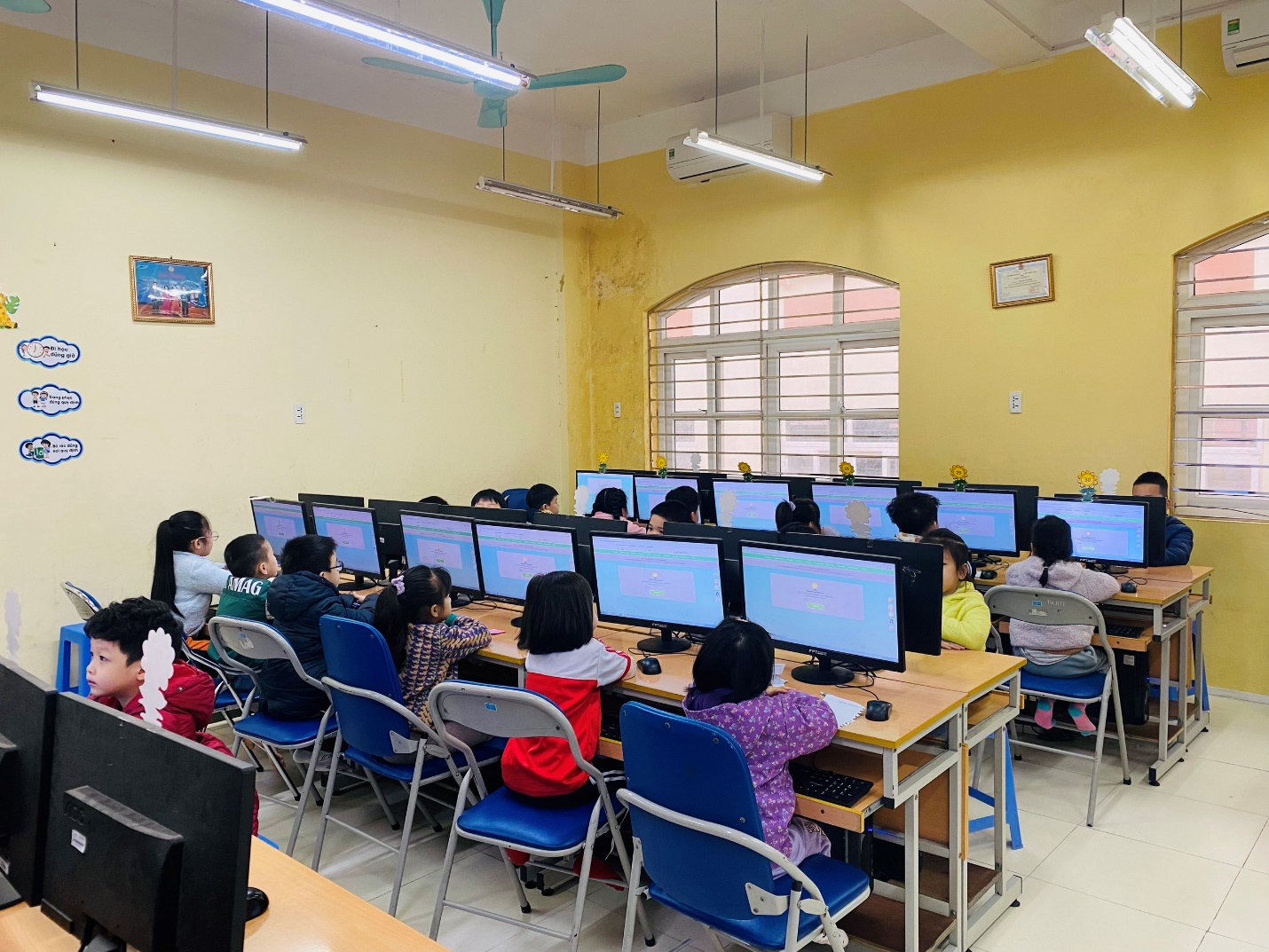 A group of children sitting in a classroom with computers

AI-generated content may be incorrect.