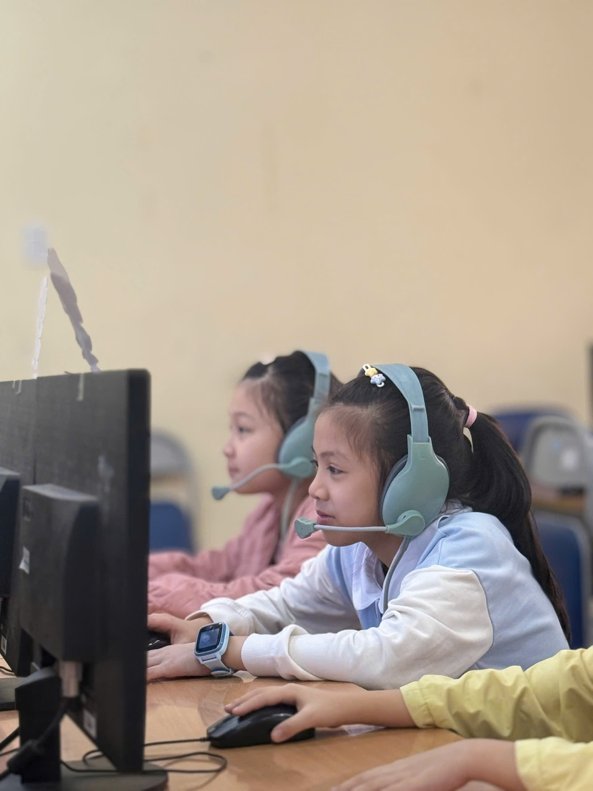 A group of children wearing headsets and sitting at a computer

AI-generated content may be incorrect.