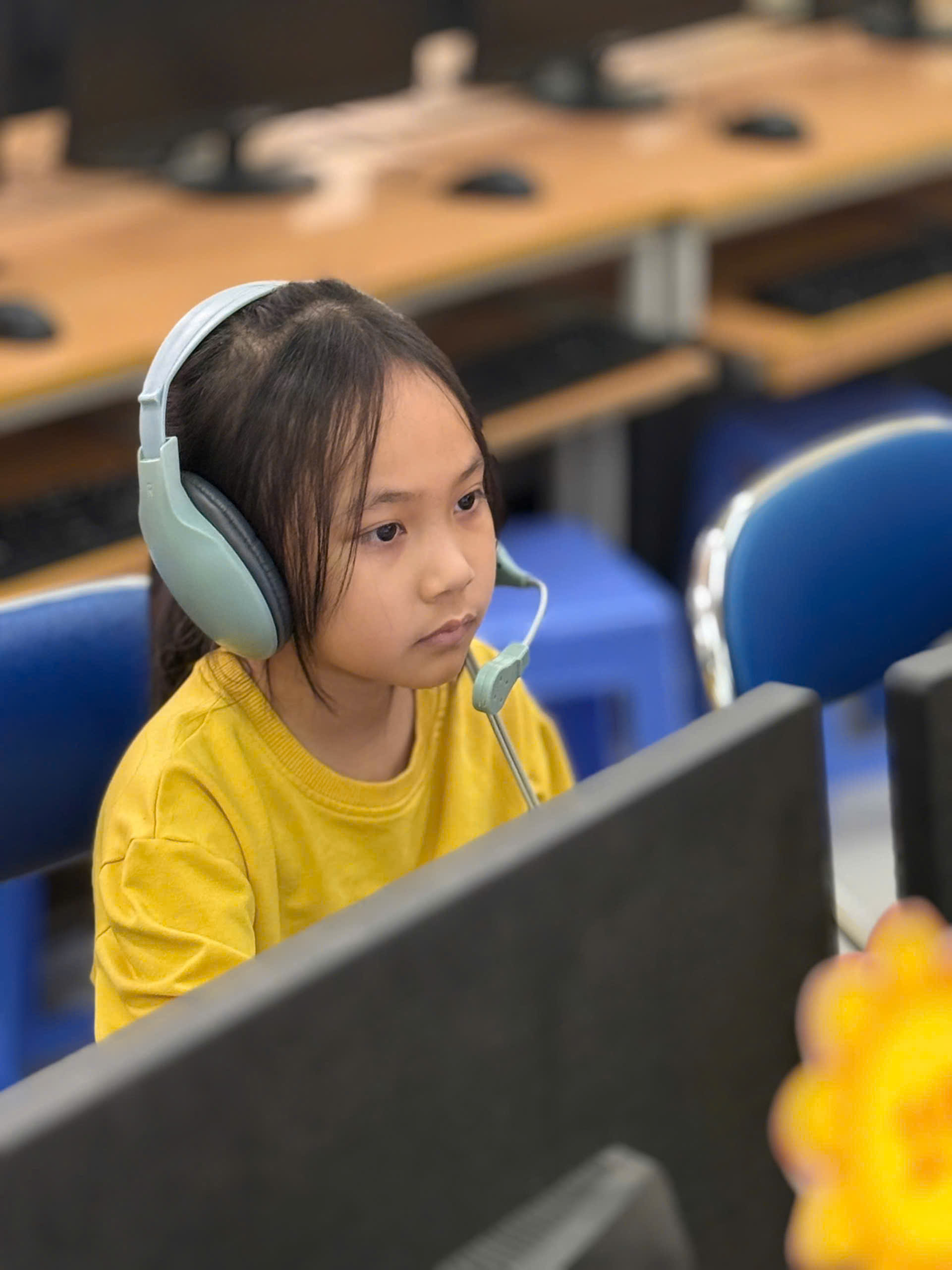A child wearing headphones and looking at a computer screen

AI-generated content may be incorrect.