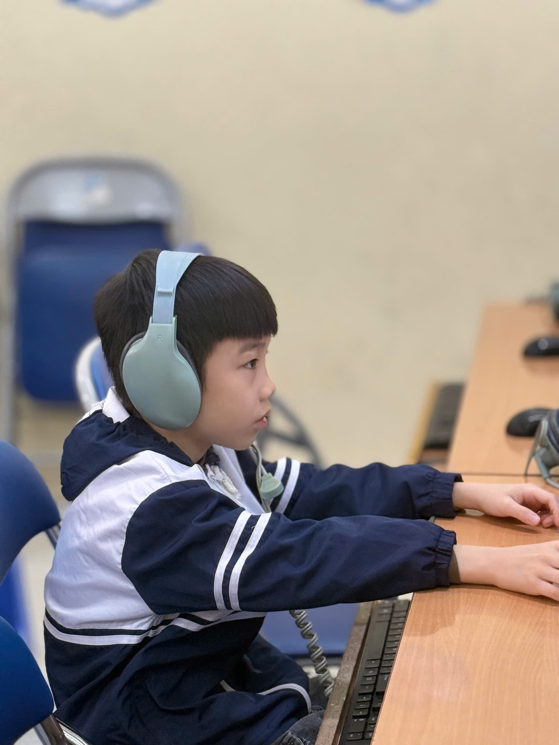 A child wearing headphones and using a computer

AI-generated content may be incorrect.