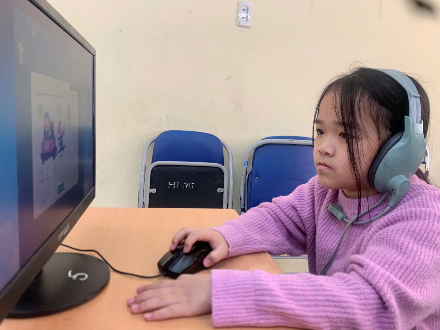 A child wearing headphones and using a computer

AI-generated content may be incorrect.