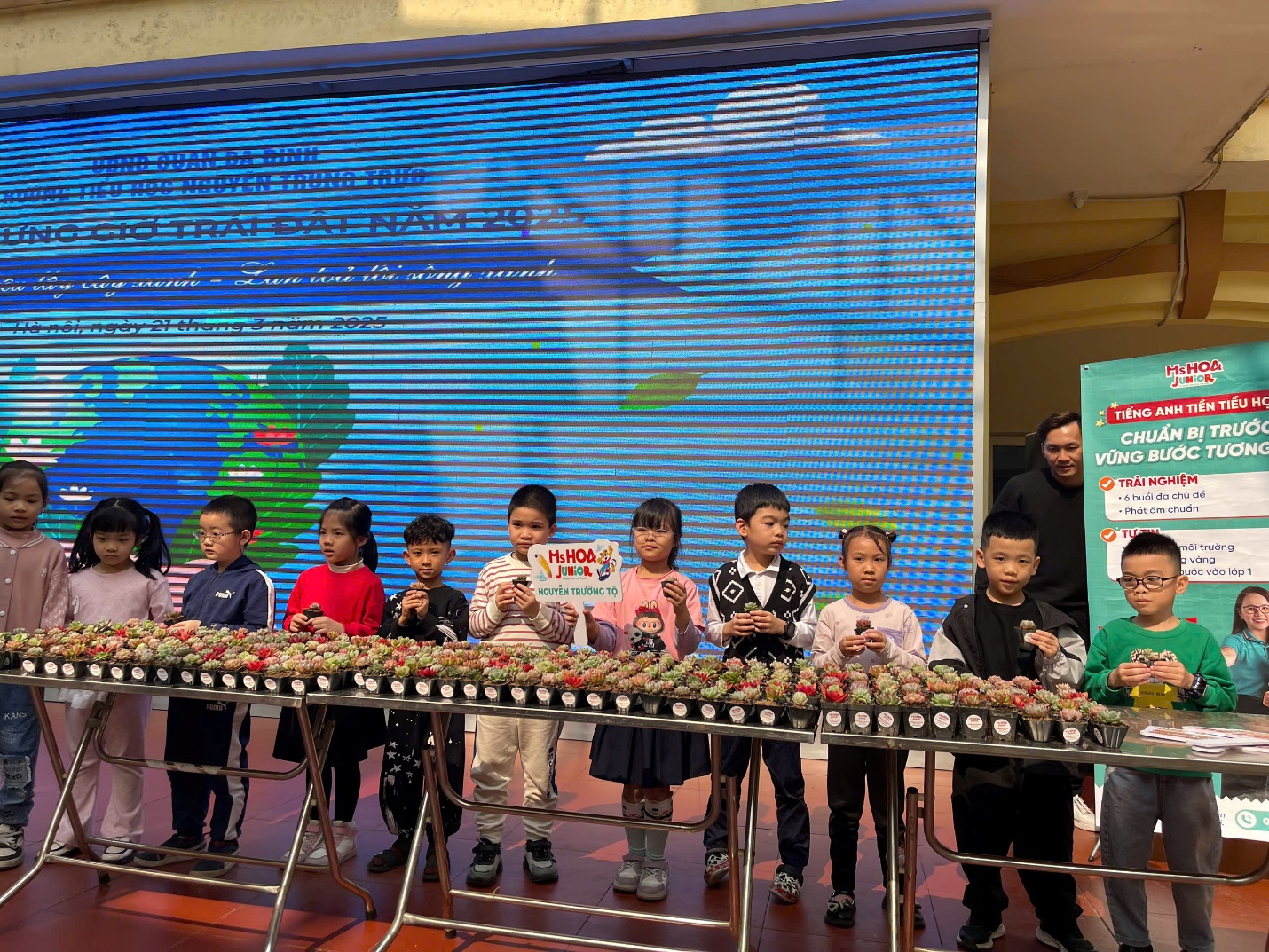 A group of children standing in front of a large screen

AI-generated content may be incorrect.