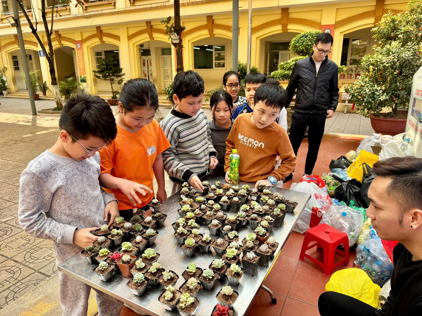 A group of kids standing around a table with small plants

AI-generated content may be incorrect.