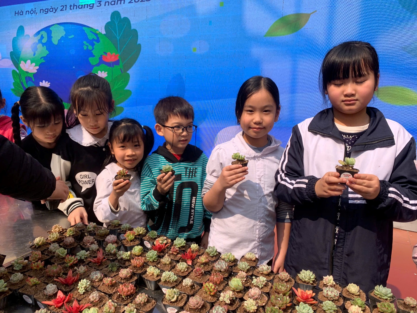 A group of children holding small plants

AI-generated content may be incorrect.
