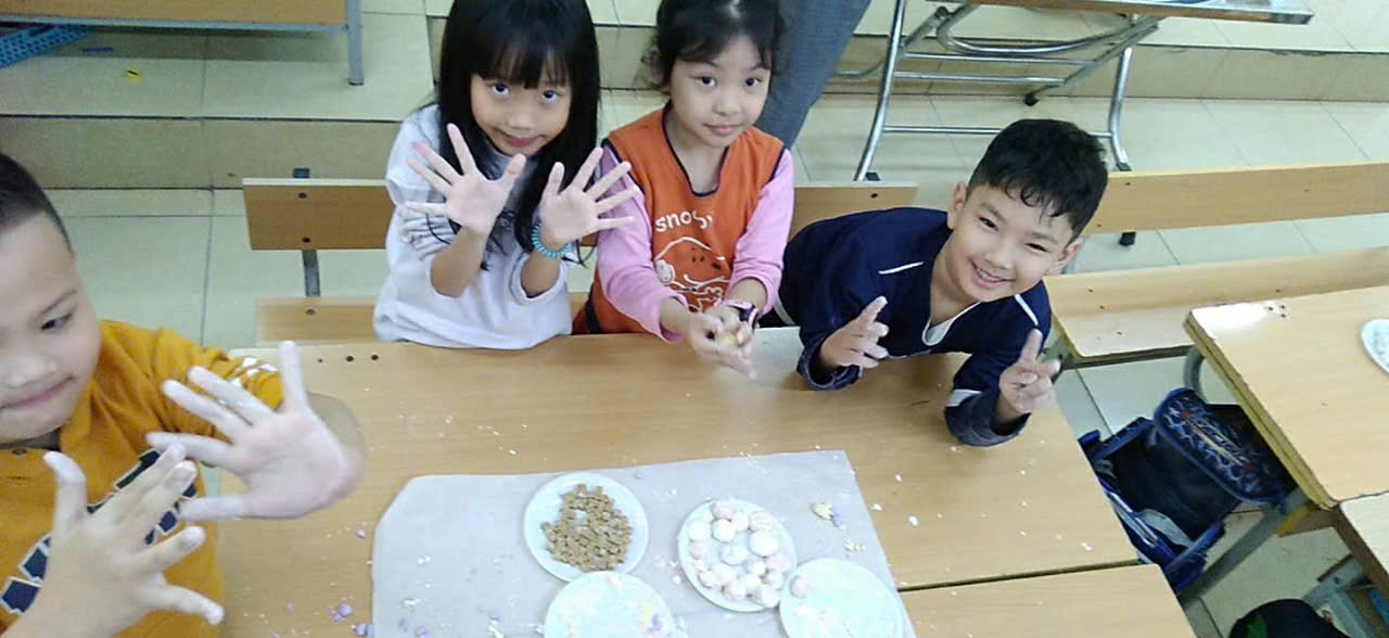 A group of children sitting at a table with plates of food
AI-generated content may be incorrect.