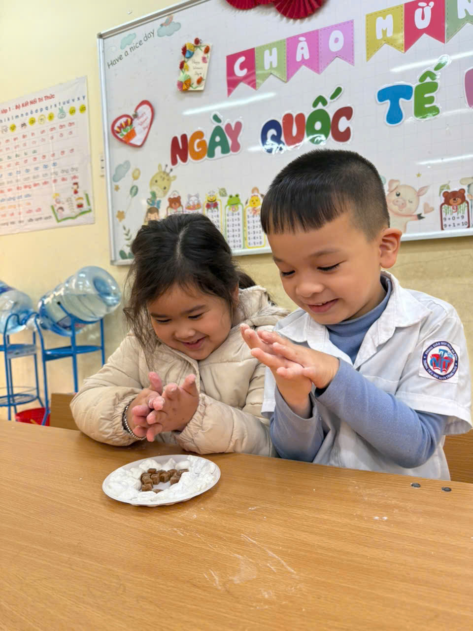 A child and child sitting at a table
AI-generated content may be incorrect.