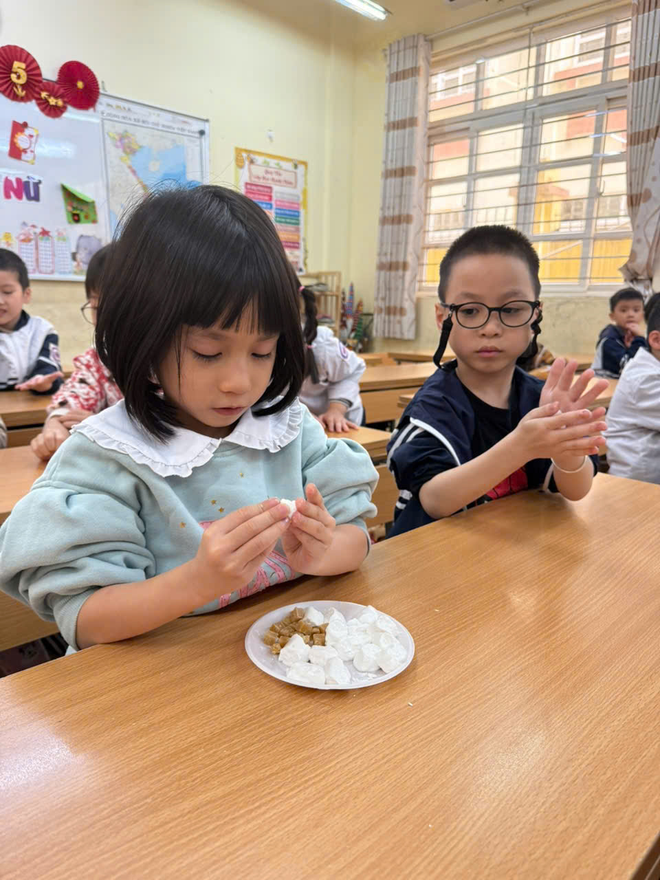 A group of children sitting at a table
AI-generated content may be incorrect.