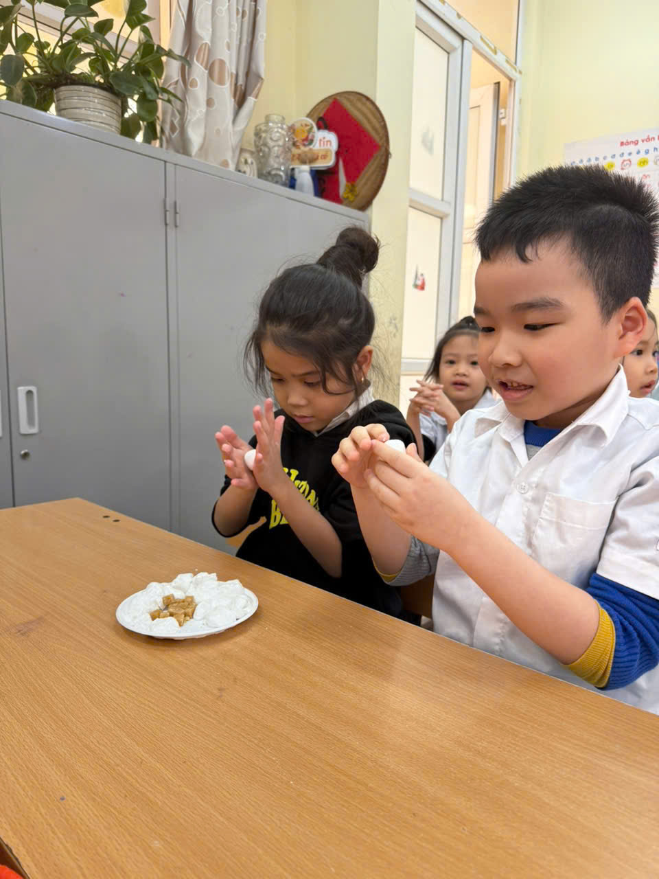 A group of children sitting at a table
AI-generated content may be incorrect.