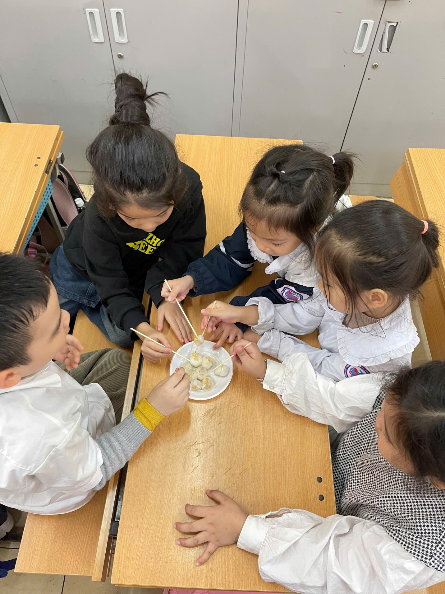 A group of children sitting at a table eating food
AI-generated content may be incorrect.