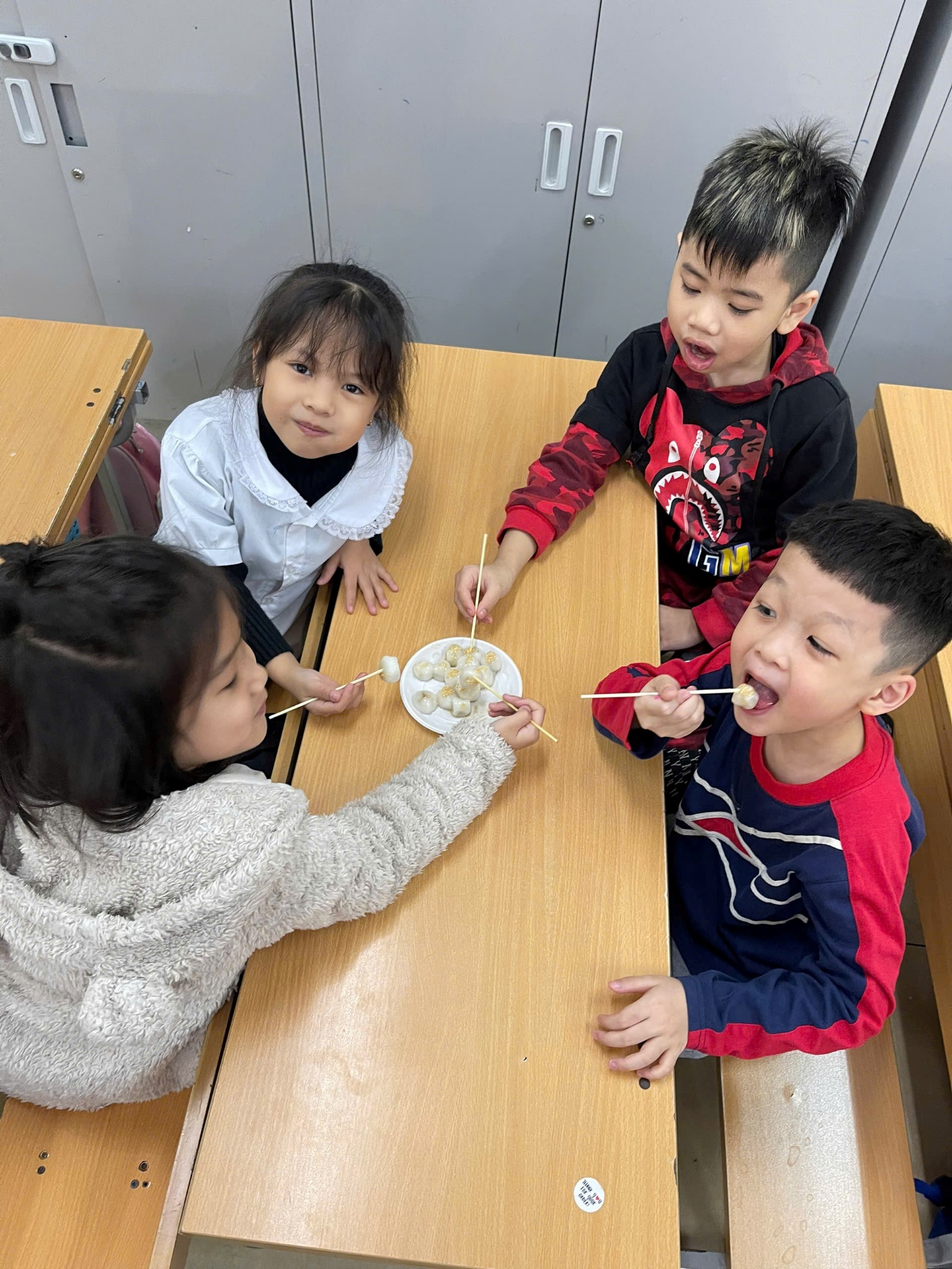 A group of children eating at a table
AI-generated content may be incorrect.