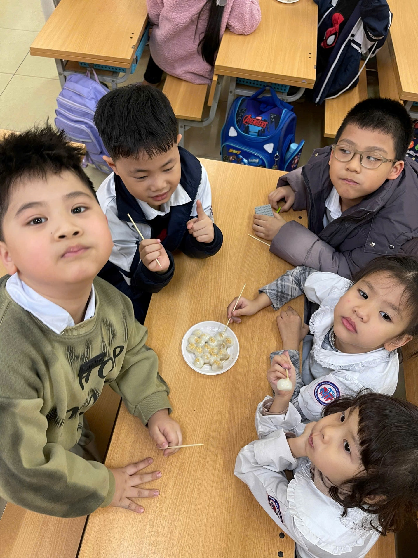 A group of children sitting around a table
AI-generated content may be incorrect.