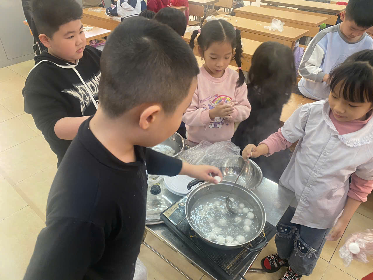 A group of children cooking in a classroom
AI-generated content may be incorrect.