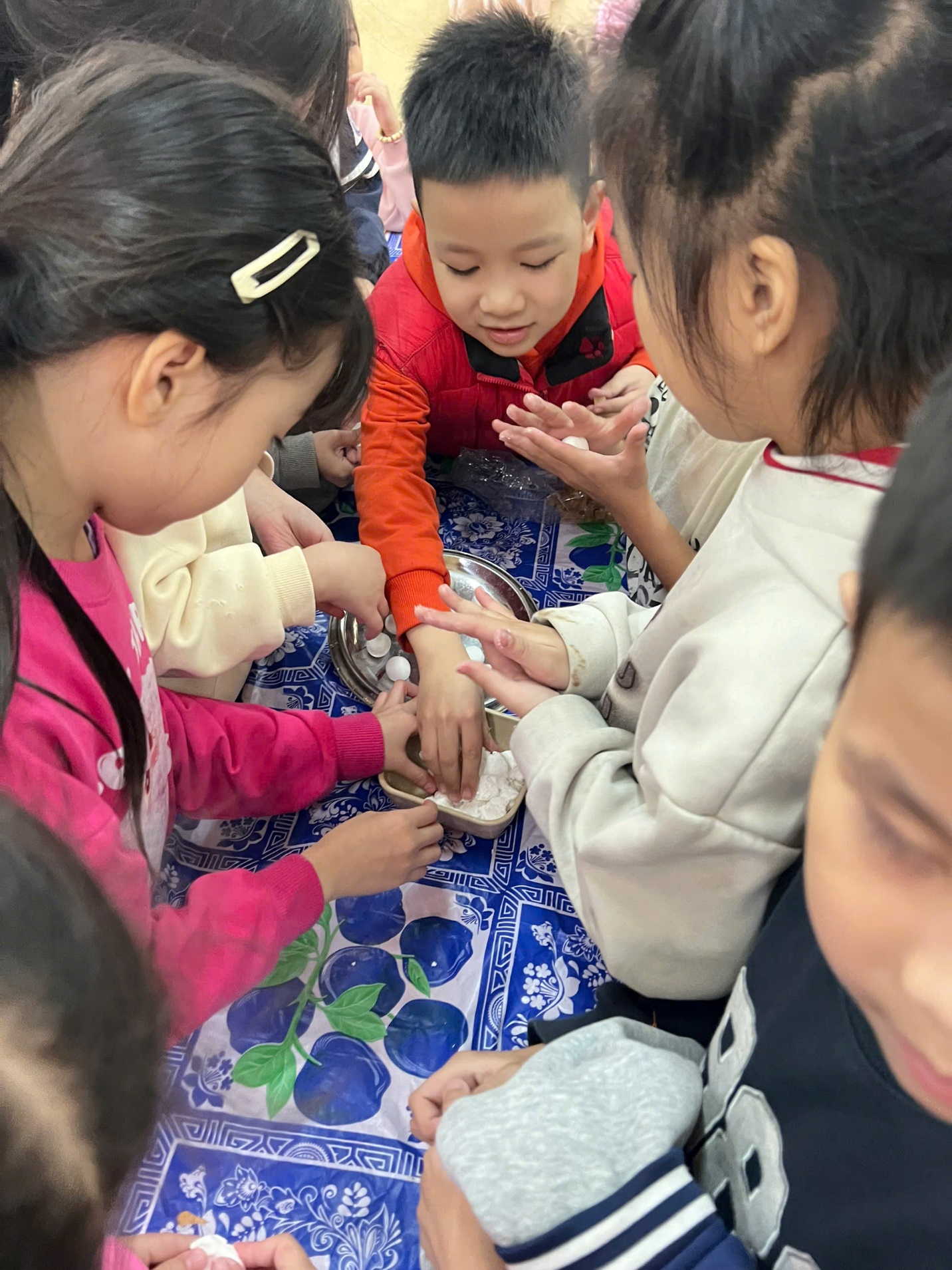 A group of children around a table
AI-generated content may be incorrect.