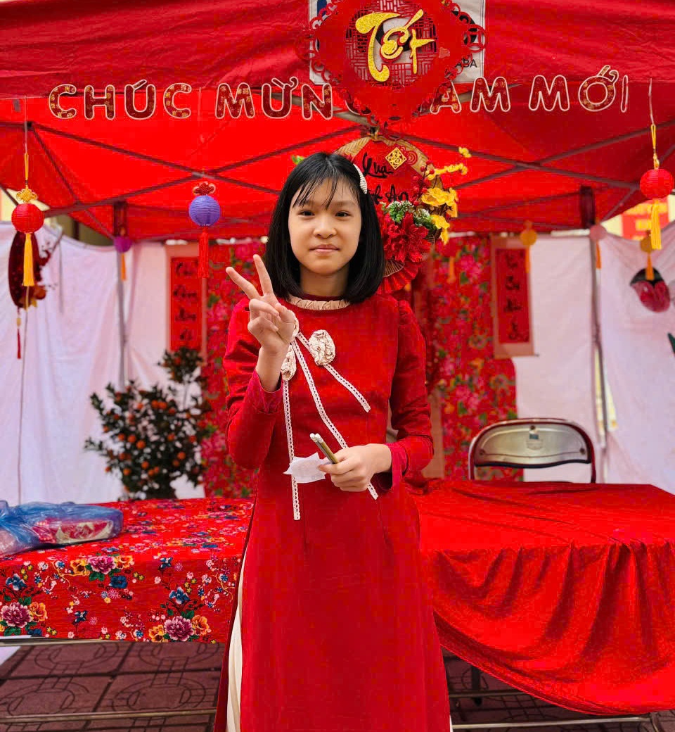 A child in a red dress holding up two fingers

AI-generated content may be incorrect.