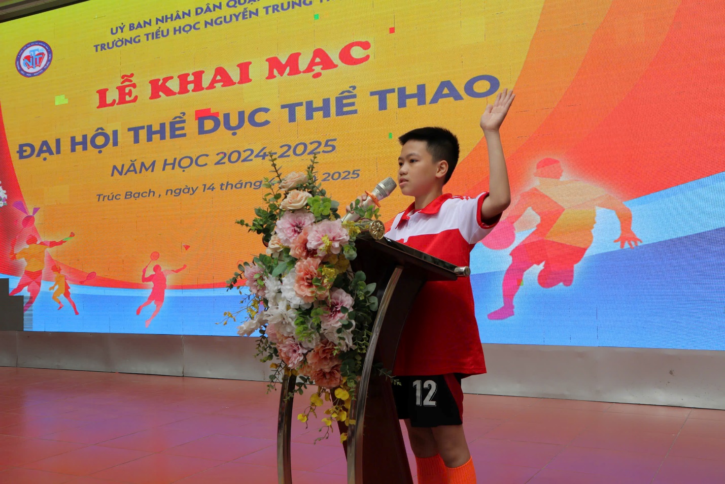 A child standing at a podium with a microphone and flowers

AI-generated content may be incorrect.