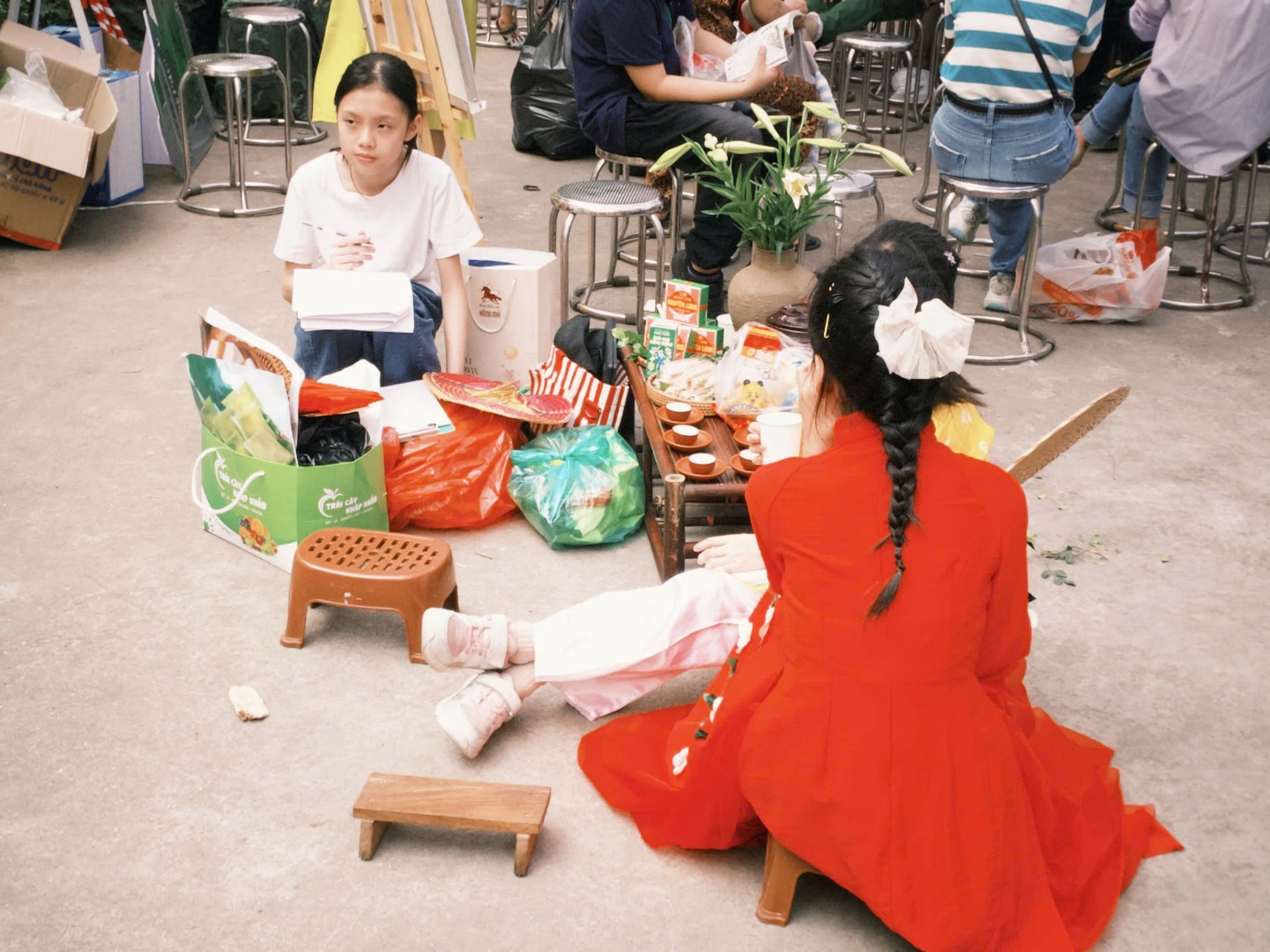 A group of people sitting on the ground
AI-generated content may be incorrect.