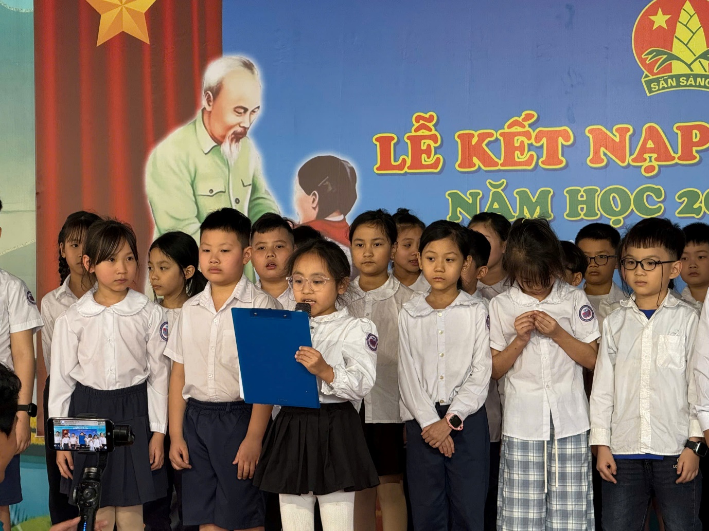 A group of children standing in front of a poster
AI-generated content may be incorrect.