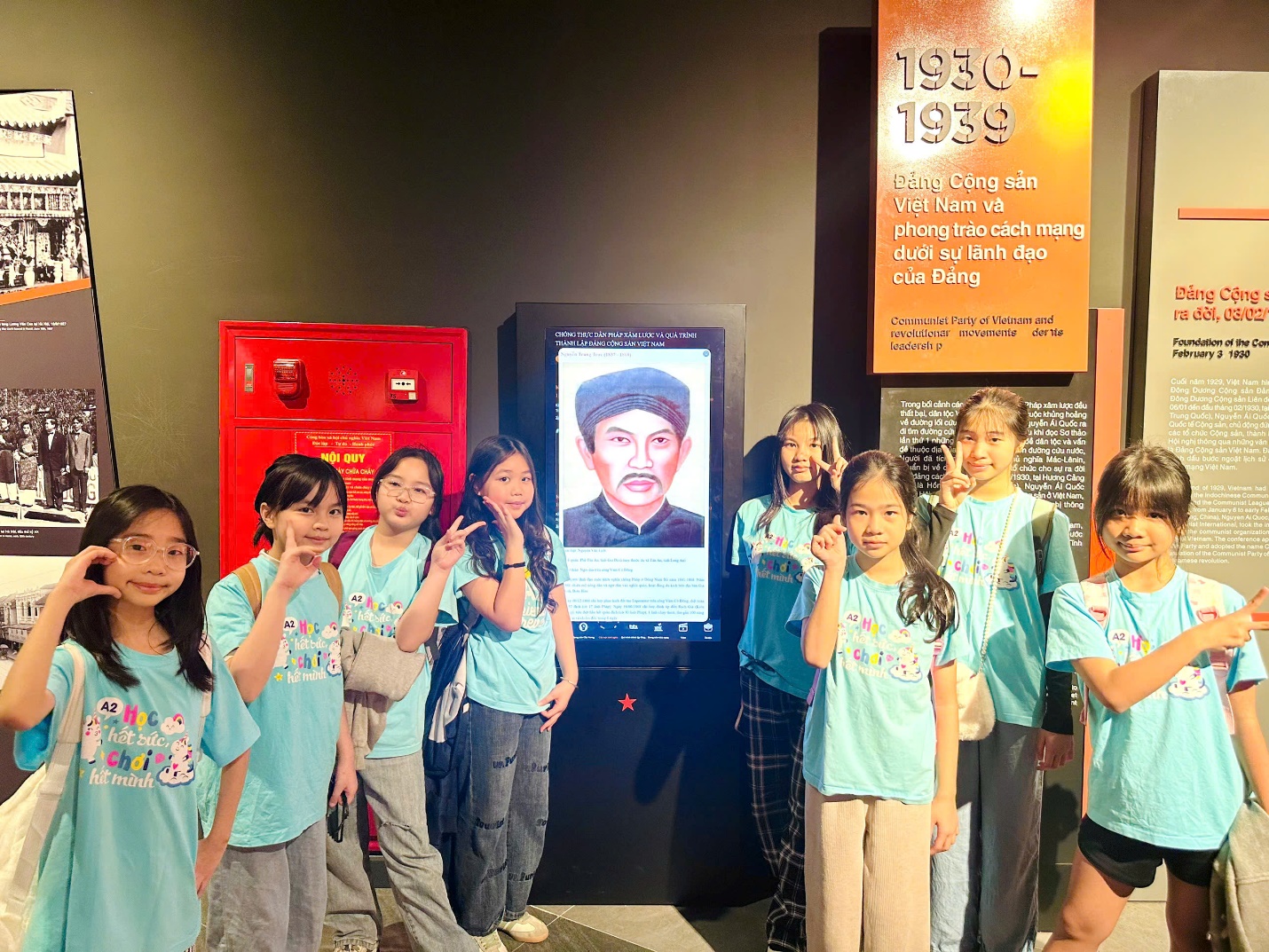 A group of children standing in front of a screen
AI-generated content may be incorrect.