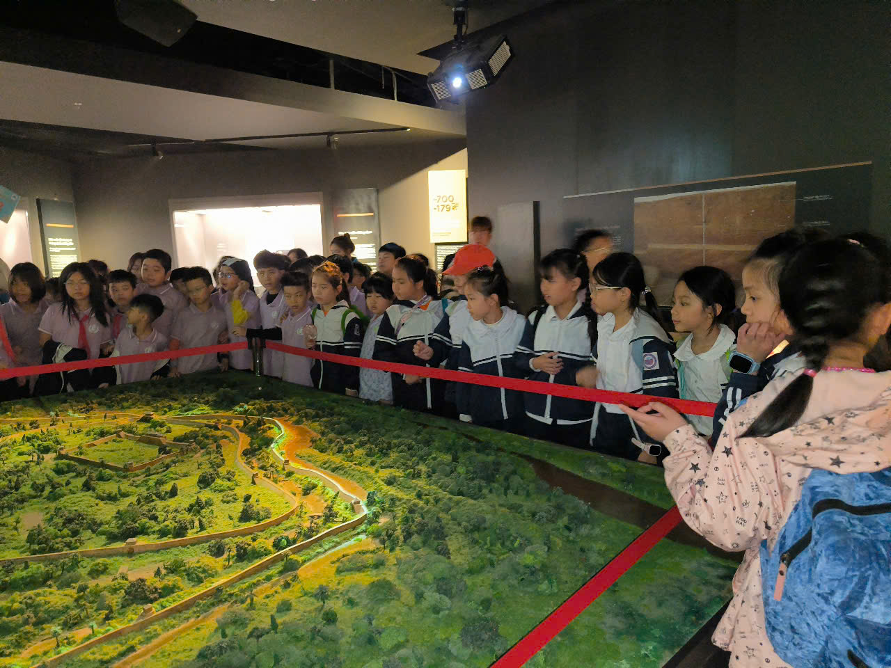 A group of children standing in a room with a map
AI-generated content may be incorrect.