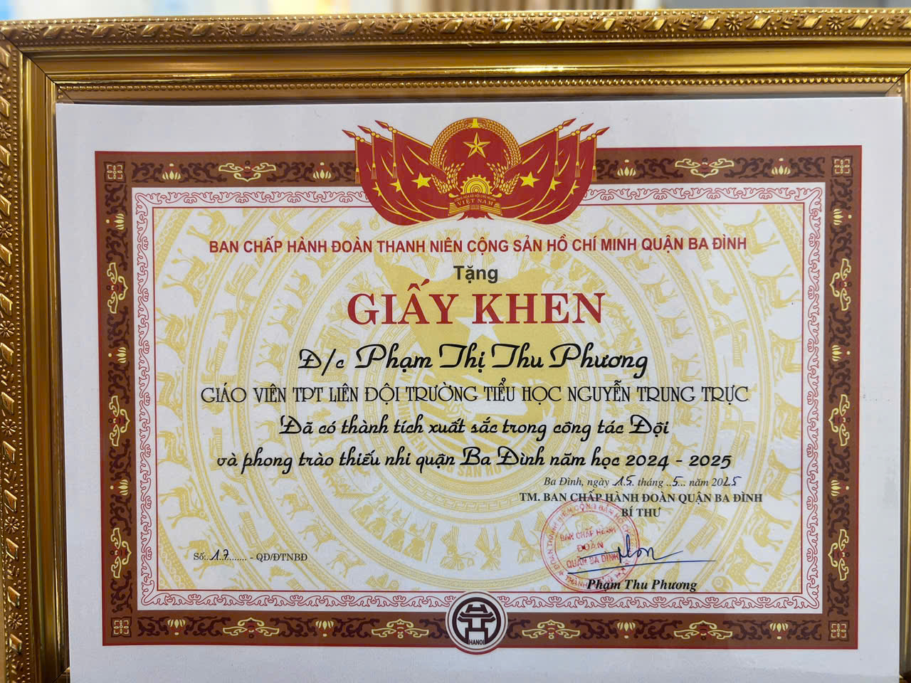 A certificate in a gold frame
AI-generated content may be incorrect.