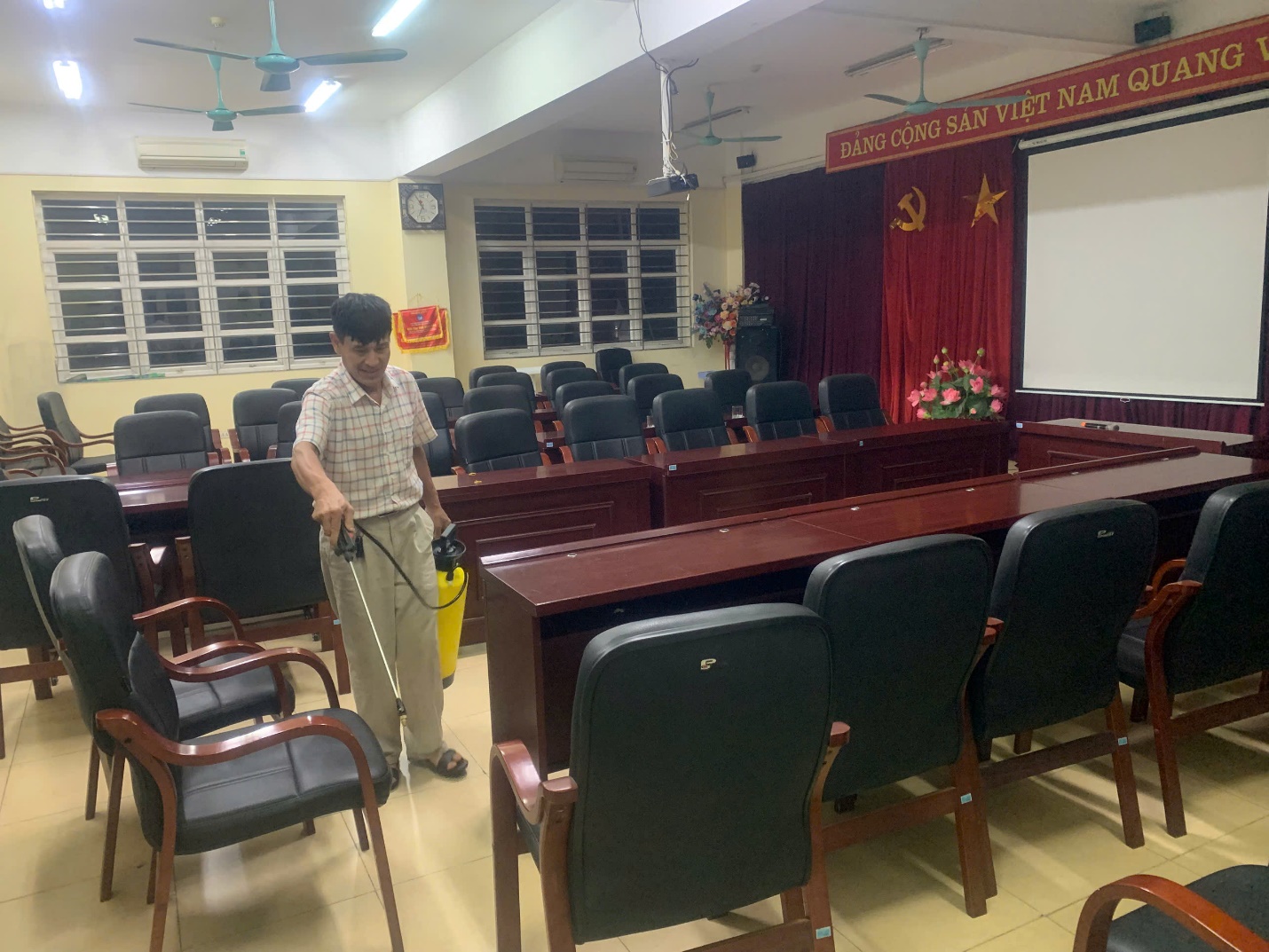 A person holding a spray object in a room with chairs

AI-generated content may be incorrect.