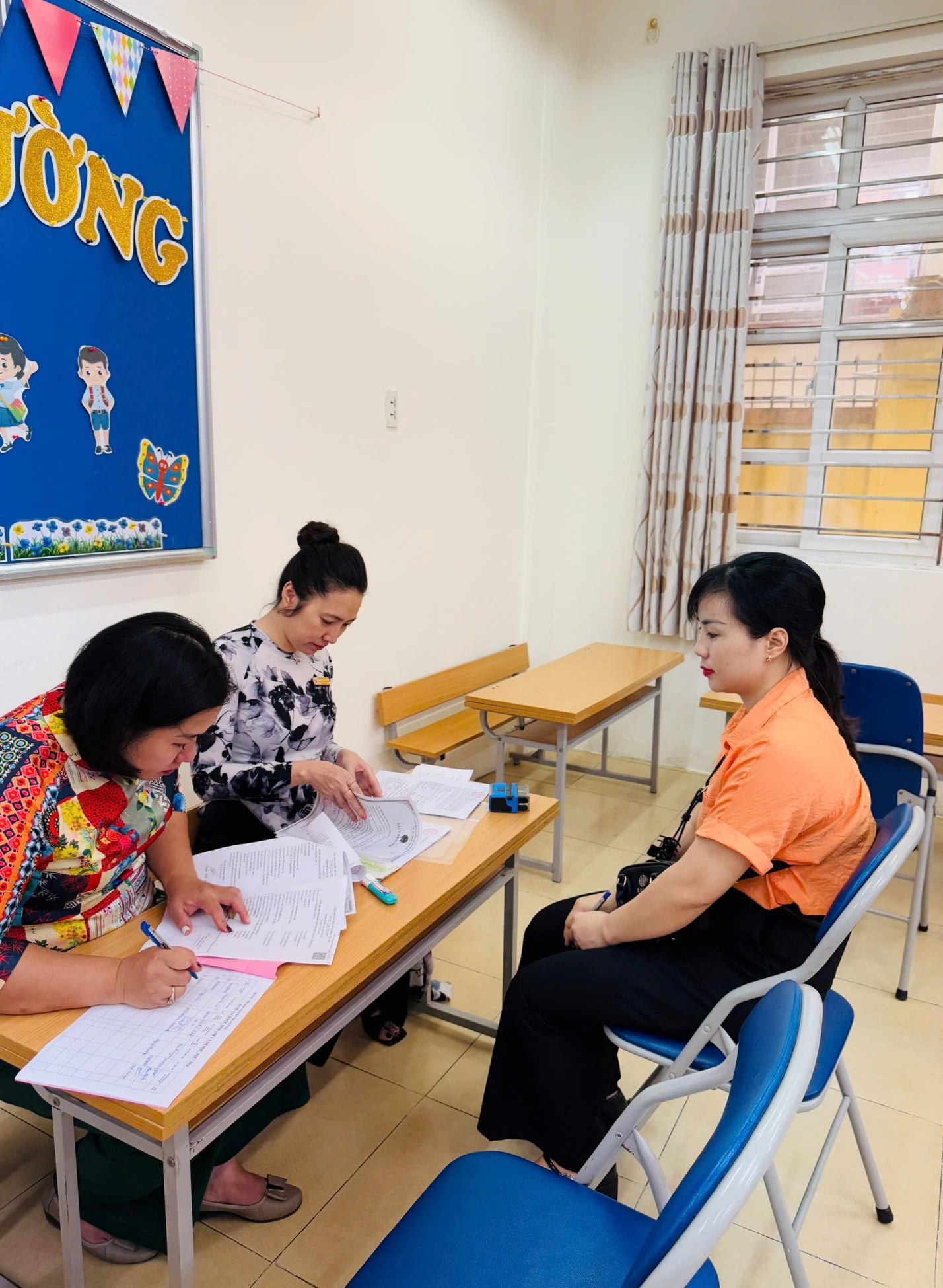 A group of women sitting at a desk

AI-generated content may be incorrect.