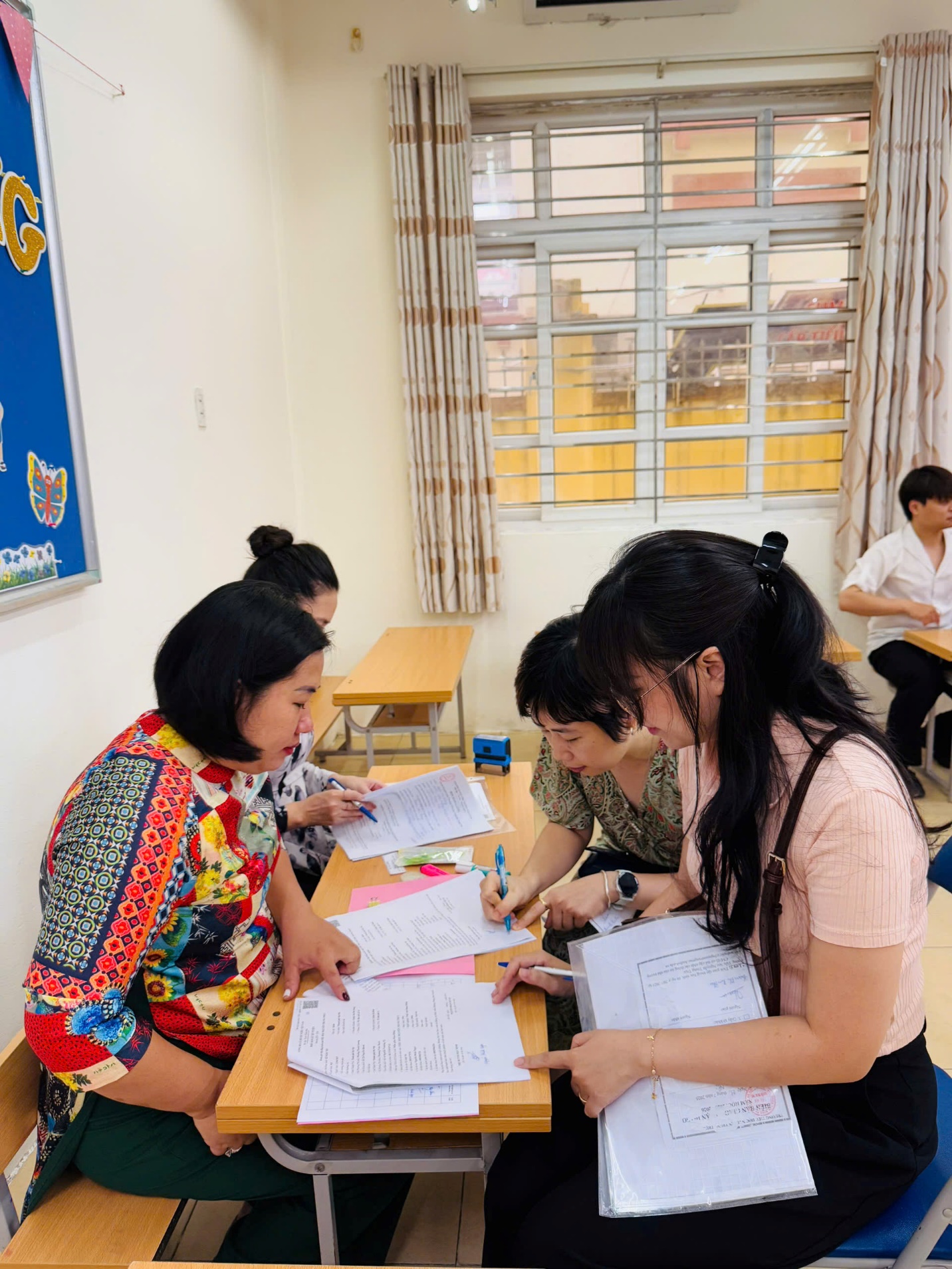 A group of people sitting at a table with papers

AI-generated content may be incorrect.