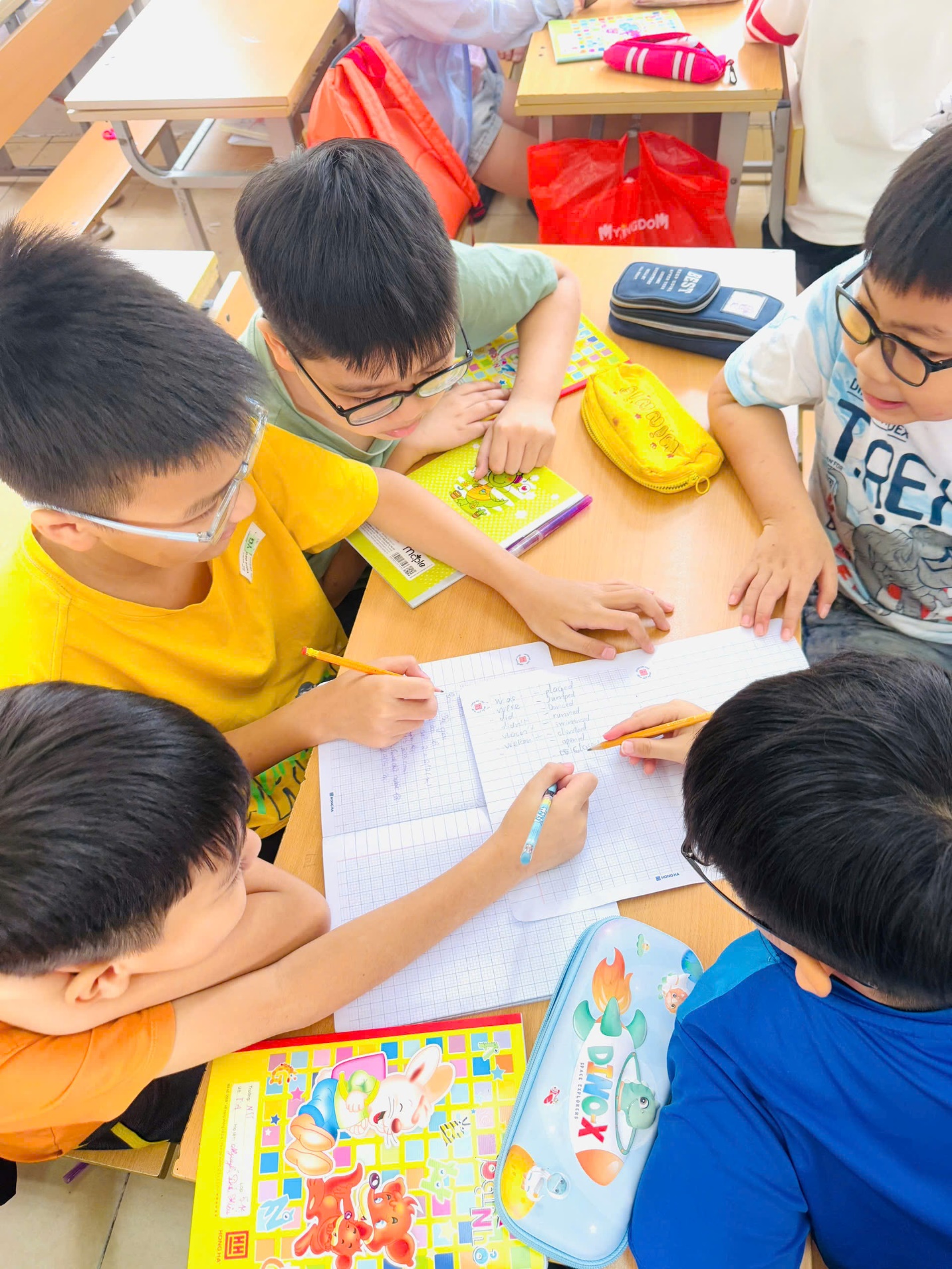 A group of children sitting at a table
AI-generated content may be incorrect.