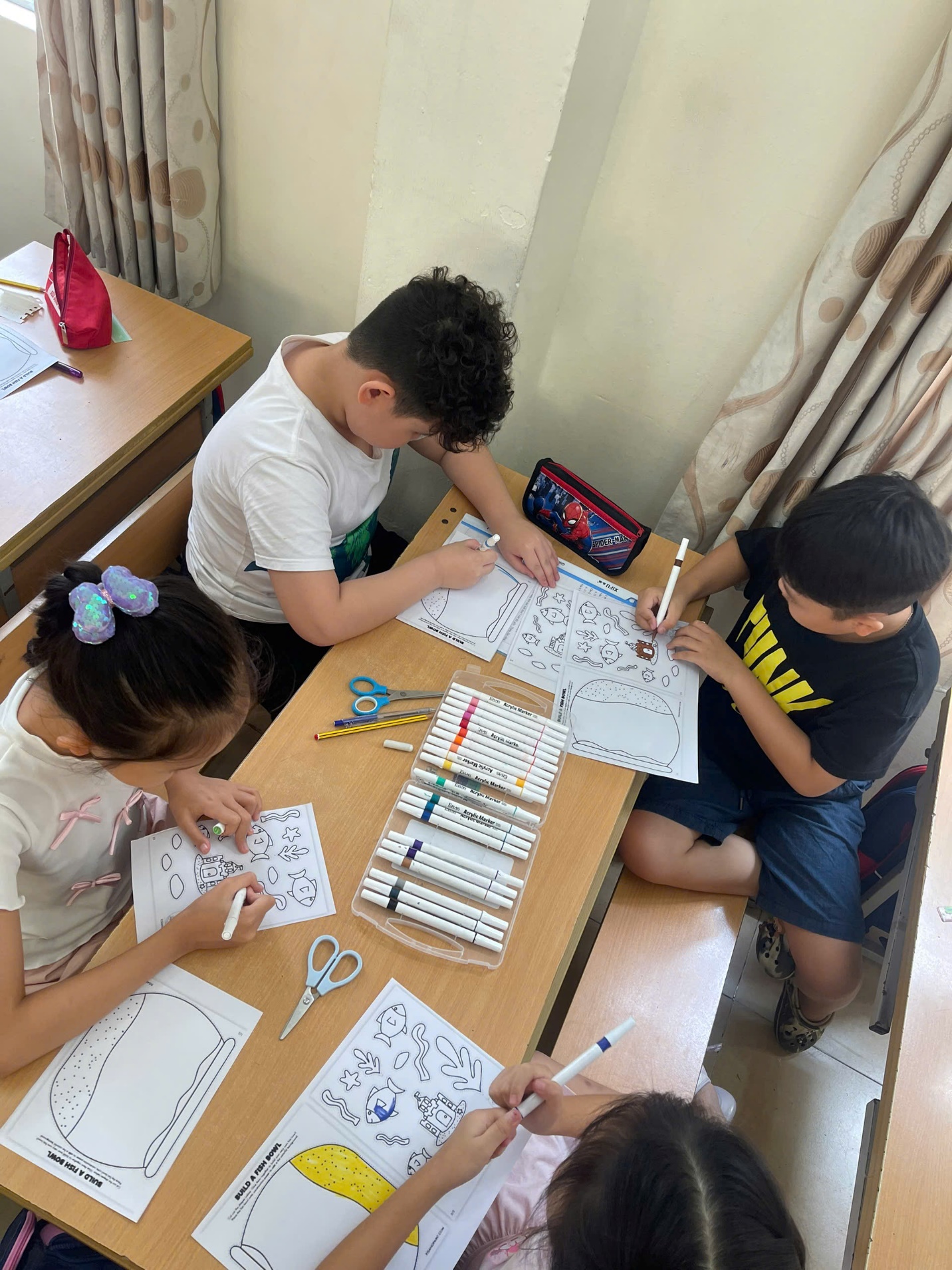 A group of kids sitting at a table drawing
AI-generated content may be incorrect.